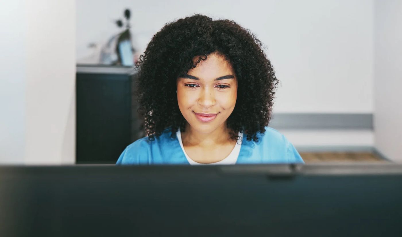A smiling woman working at her computer