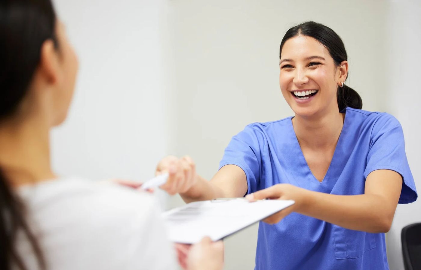 A veterinarian handing a printed summary to a smiling client
