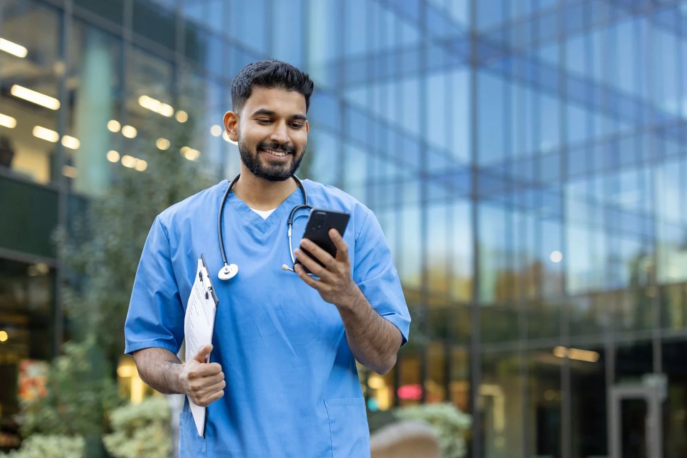 A veterinarian checking PetWise on his phone outside the clinic