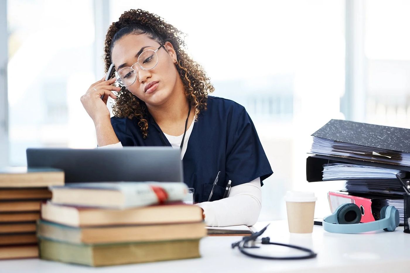 A tired veterinarian surrounded by textbooks